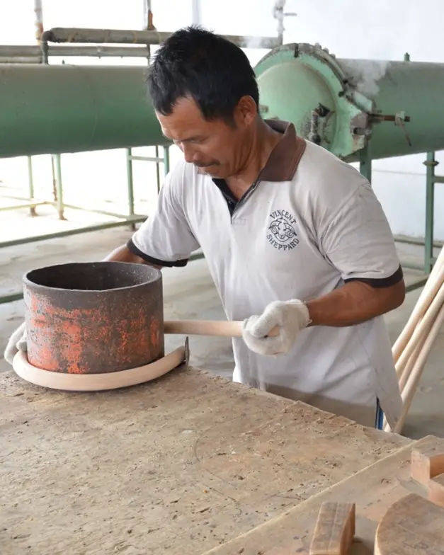  Artisan at Vincent Sheppard factory bending rattan around a heated mold to form a furniture frame.